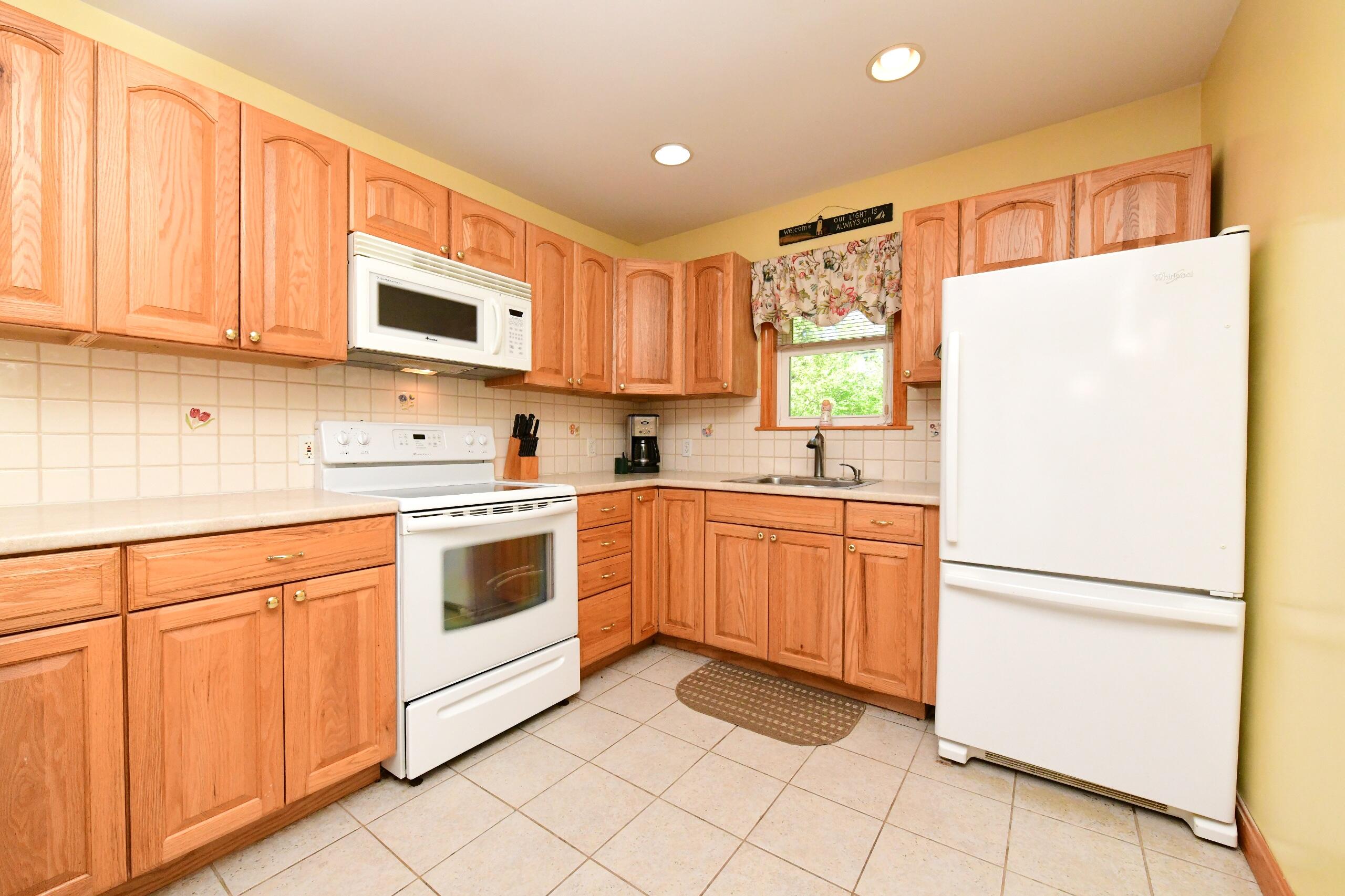 173 Standish Road Sagamore Beach, MA 02562 - Photo 7 of 39 a kitchen with stainless steel appliances granite countertop a refrigerator sink and white cabinets