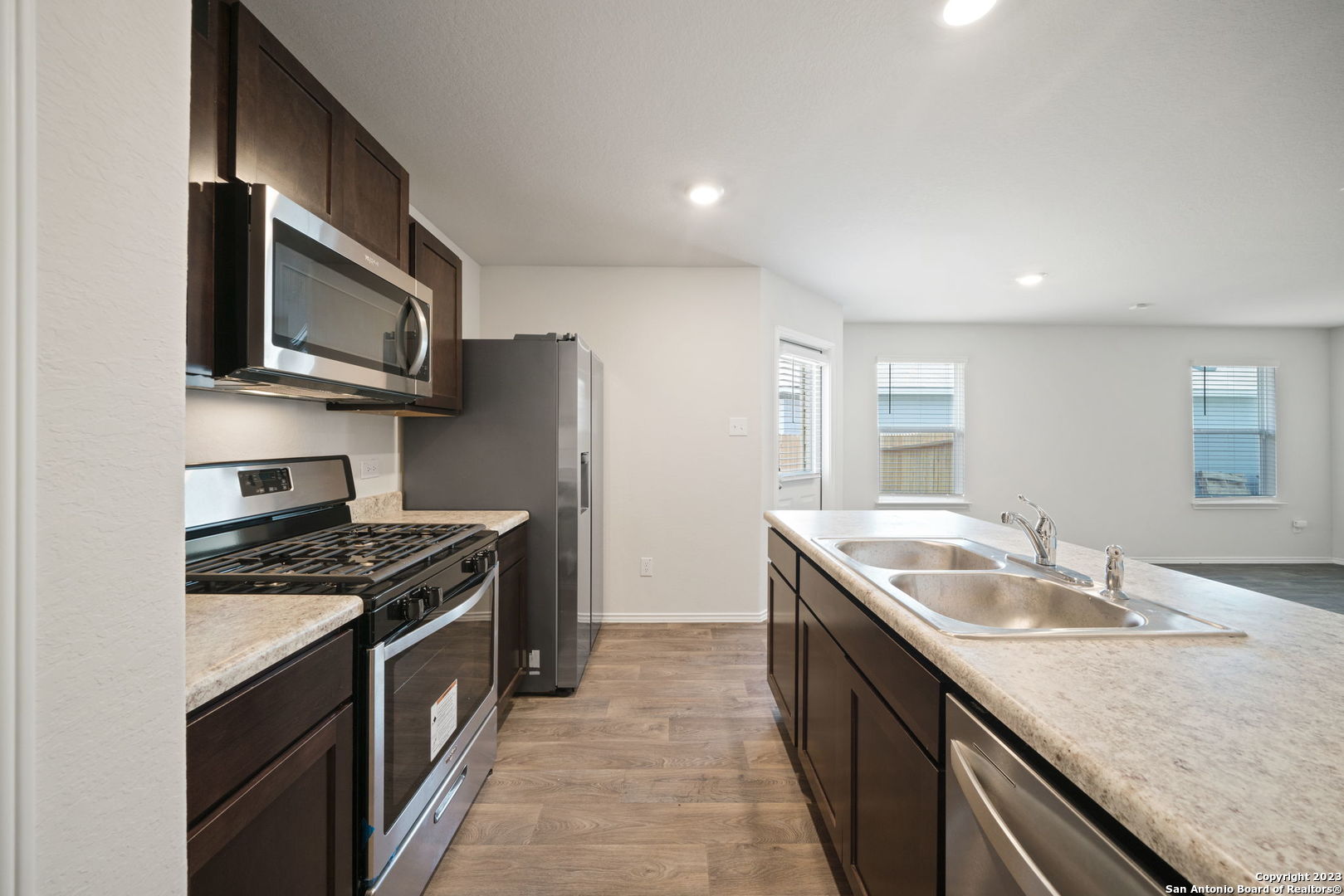 5830 Kendall Prairie Converse, TX 78109 - Photo 13 of 25 a kitchen with granite countertop stainless steel appliances a sink stove and microwave