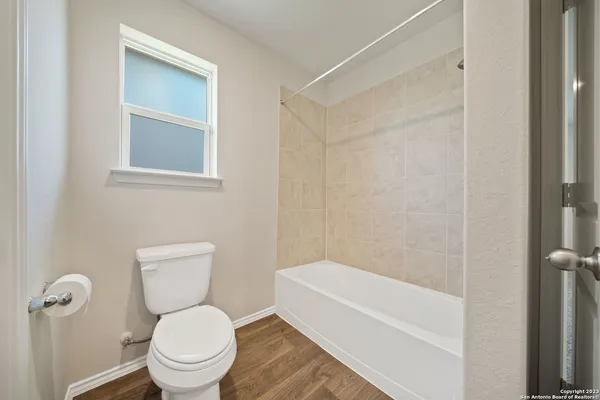 a white toilet sitting next to a bath tub