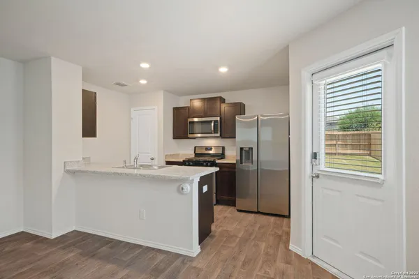 a kitchen with stainless steel appliances granite countertop a stove a sink and a refrigerator