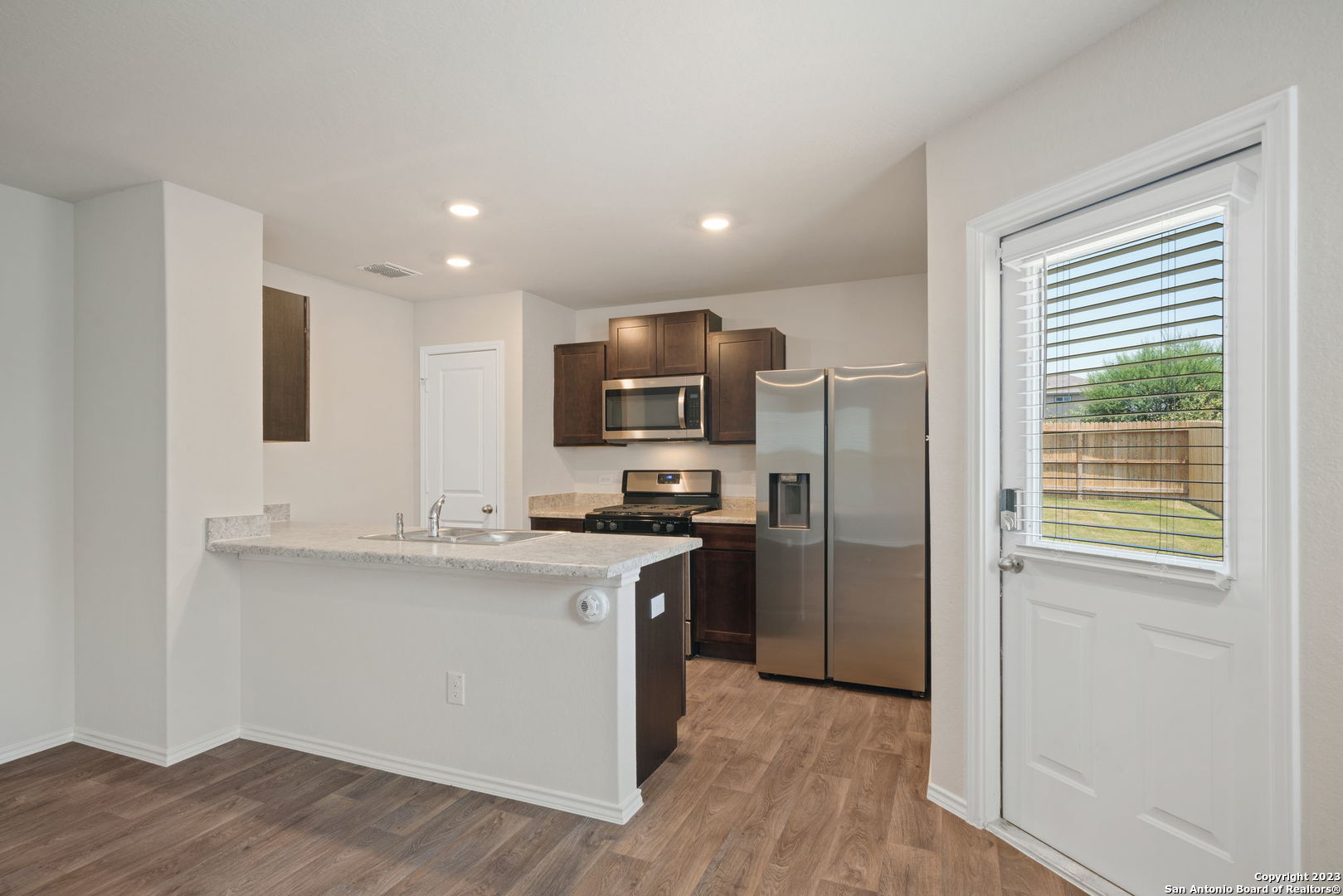 5830 Kendall Prairie Converse, TX 78109 - Photo 10 of 25 a kitchen with stainless steel appliances granite countertop a stove a sink and a refrigerator