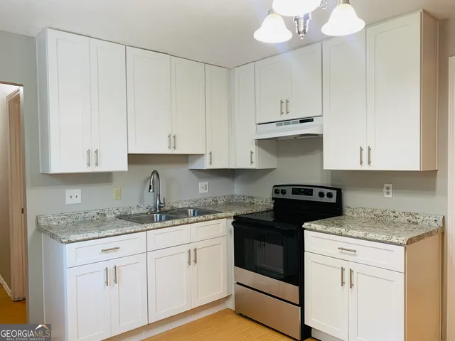 a kitchen with white cabinets and white appliances