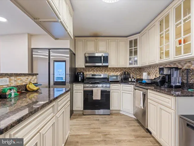 a kitchen with stainless steel appliances granite countertop a stove and a sink