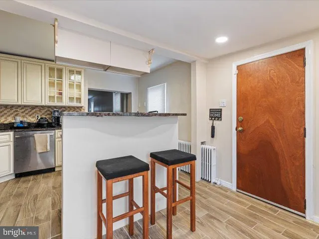 a kitchen with stainless steel appliances granite countertop a refrigerator a stove top oven a sink with island and chairs