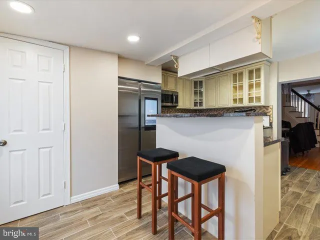 a kitchen with stainless steel appliances granite countertop a refrigerator a stove and a wooden cabinets