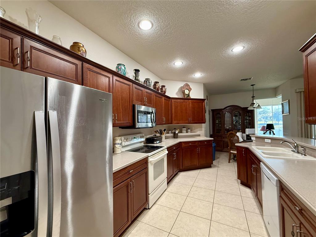 15425 Southwest 14th Avenue Road Ocala, FL 34473 - Photo 6 of 21 a kitchen with stainless steel appliances granite countertop a refrigerator a stove a sink a microwave and island
