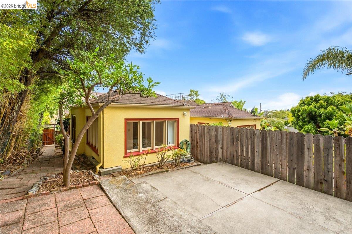 2403 Cedar Street Berkeley, CA 94708 - Photo 32 of 33 Rear exterior featuring a yellow stucco finish and a brown shingle roof