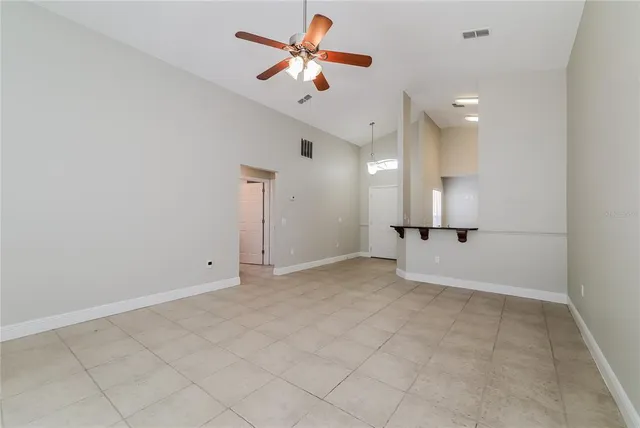 an empty room with a ceiling fan and a rug