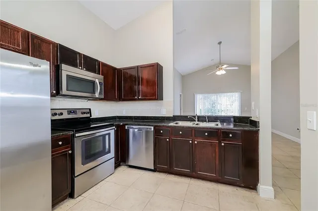 a kitchen with stainless steel appliances granite countertop a stove top oven microwave and refrigerator