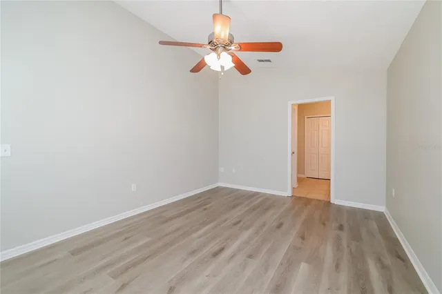 a view of a room with wooden floor fan and window