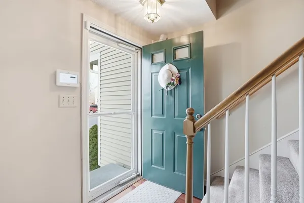 a view of a hallway with wooden floor and staircase