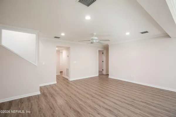 an empty room with window and ceiling fan