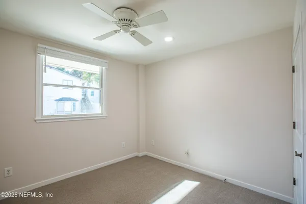 a view of an empty room with a fireplace and a window