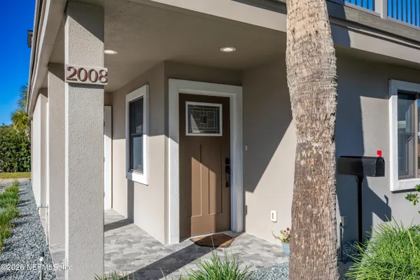 a view of a hallway with wooden floor and a bathroom