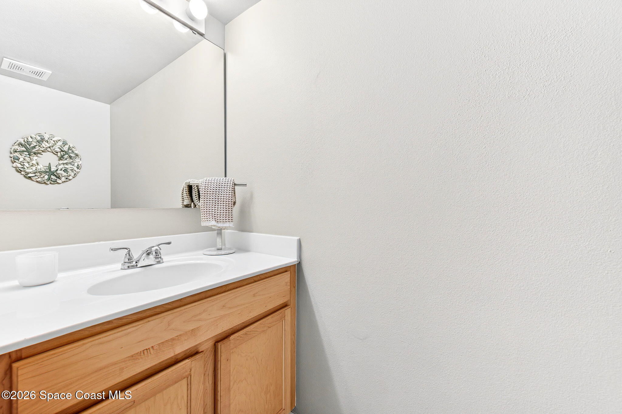 2186 Spring Creek Circle Palm Bay, FL 32905 - Photo 20 of 40 a bathroom with a sink and a mirror