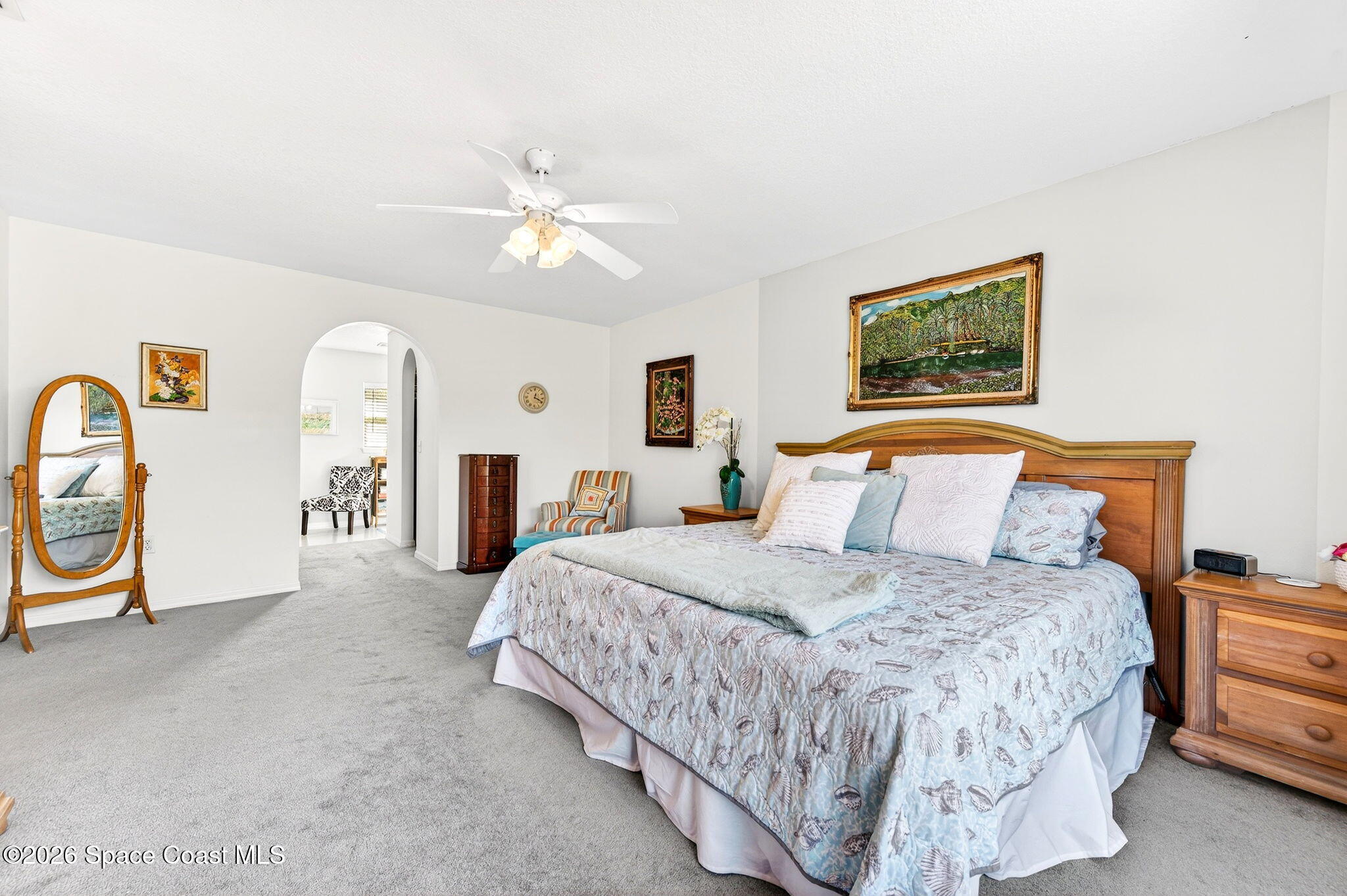 2186 Spring Creek Circle Palm Bay, FL 32905 - Photo 24 of 40 a bedroom with a bed a painting on the wall and a chandelier