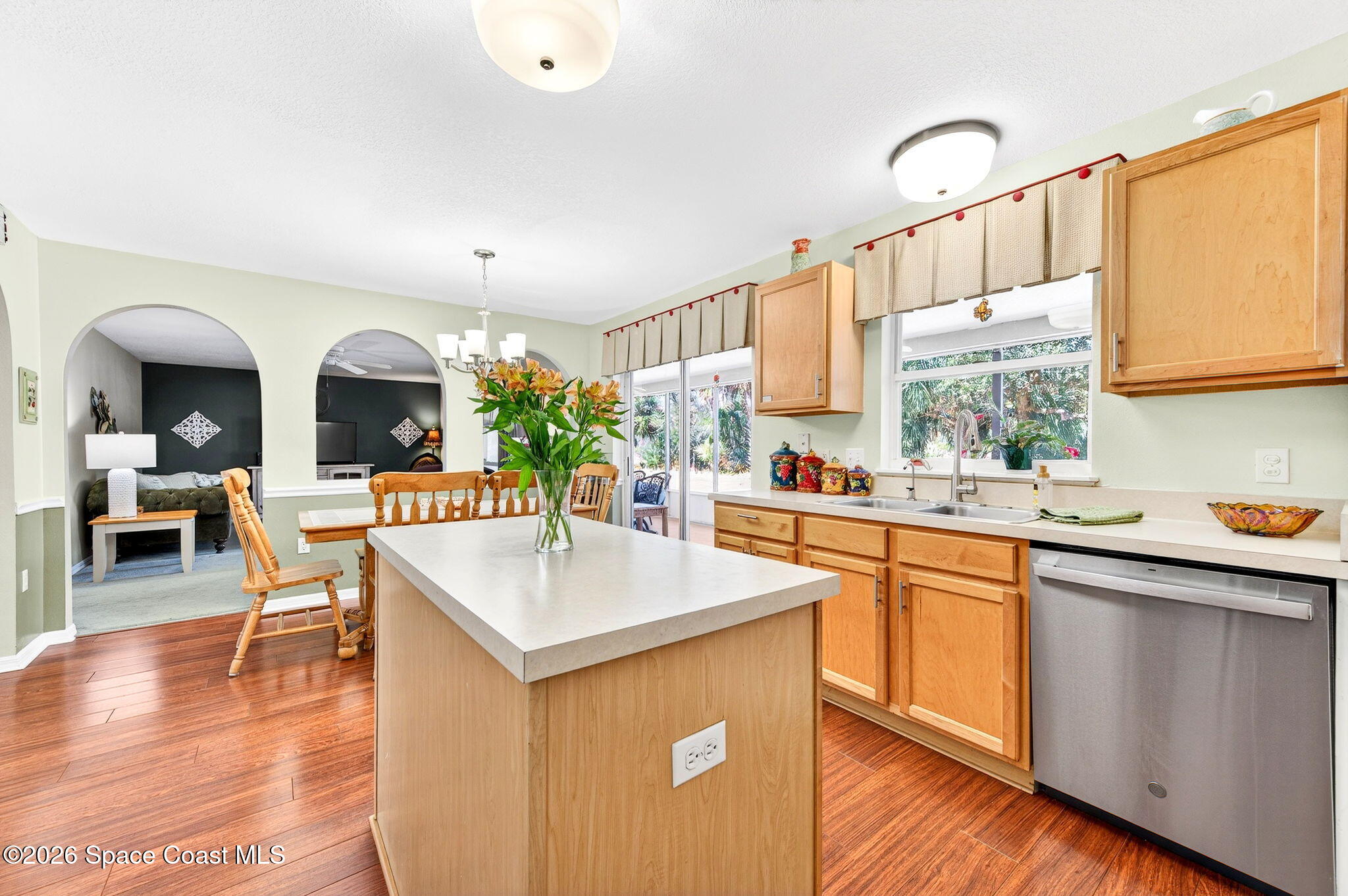 2186 Spring Creek Circle Palm Bay, FL 32905 - Photo 9 of 40 a living room with stainless steel appliances kitchen island granite countertop a sink dishwasher and white cabinets with wooden floor