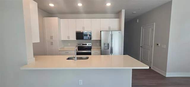 a kitchen with stainless steel appliances a refrigerator and a stove top oven