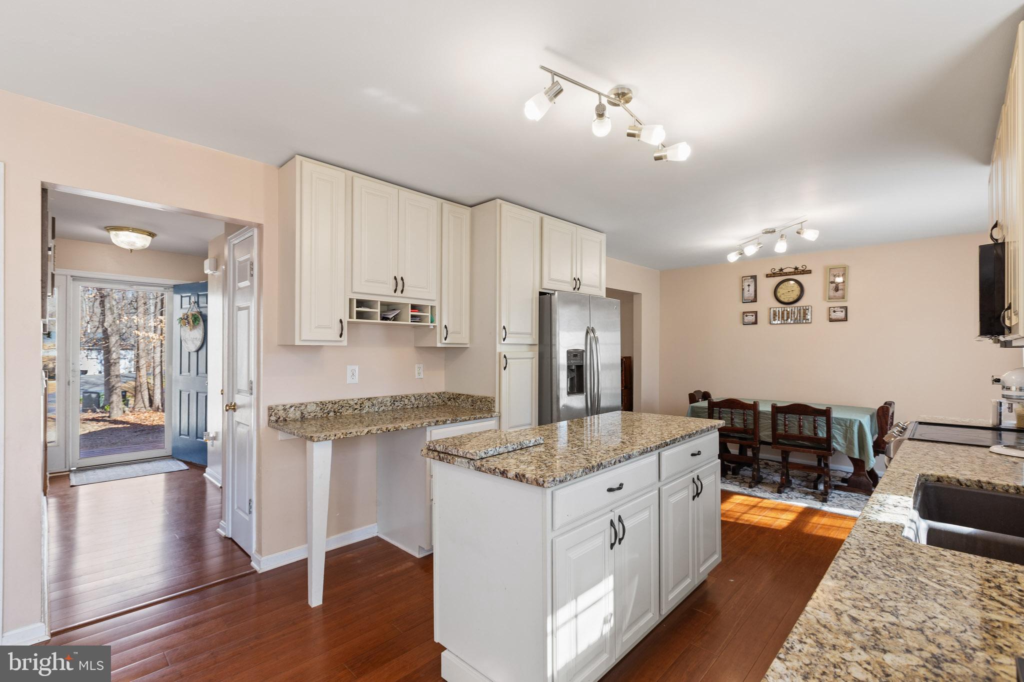 9279 Inaugural Drive King George, VA 22485 - Photo 10 of 30 a large kitchen with kitchen island granite countertop a refrigerator and wooden floor