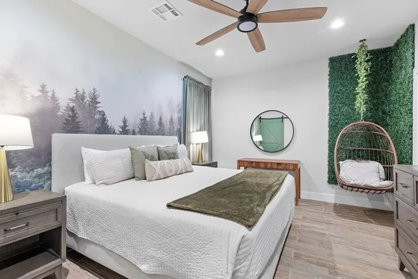 a bedroom with a bed a mirror and lamp