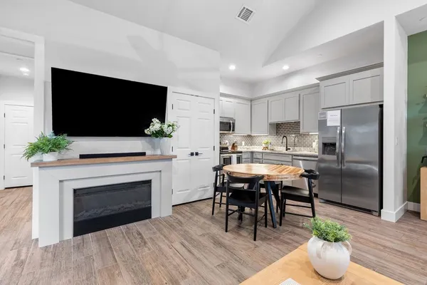 a kitchen with a refrigerator and a fireplace