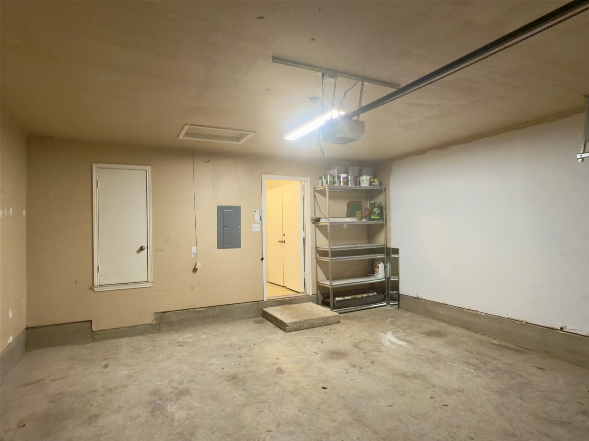 255 Myrtle Street Kyle, TX 78640 - Photo 27 of 31 Garage space with a concrete floor, an overhead garage door track system, and an exposed electrical panel