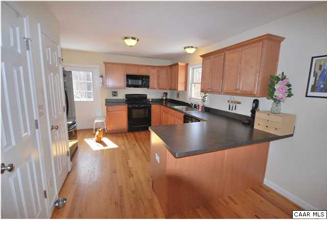 112 Roy's Place Charlottesville, VA 22902 - Photo 4 of 14 a kitchen with stainless steel appliances granite countertop a refrigerator a stove top oven a sink dishwasher and wooden cabinets with wooden floor