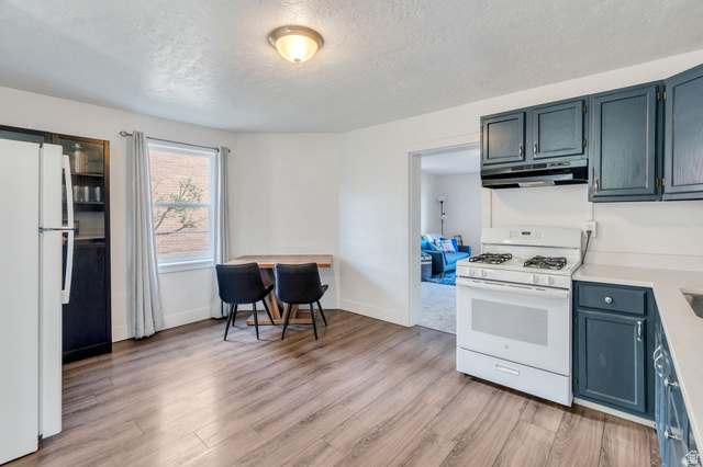 358 400 South Provo, UT 84601 - Photo 3 of 34 Kitchen featuring white appliances, light countertops, light wood flooring and blue cabinets.