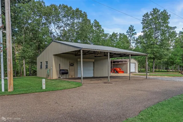 a view of a house with a yard and large trees