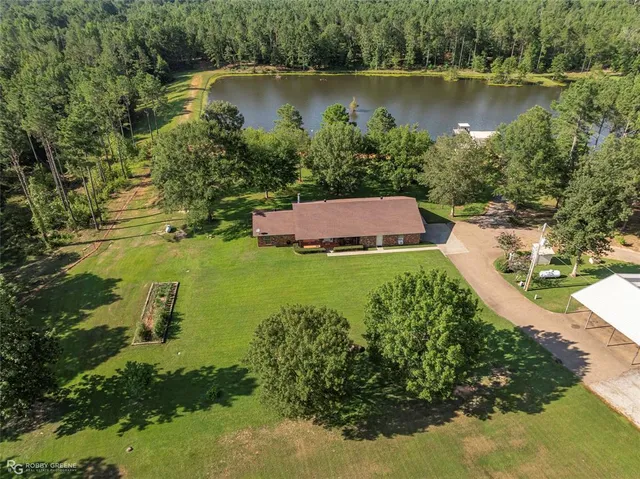 an aerial view of a house with a yard and lake view