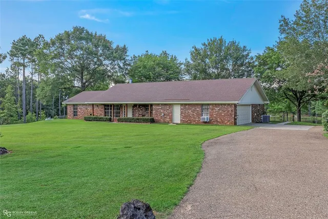a aerial view of a house next to a big yard with large trees