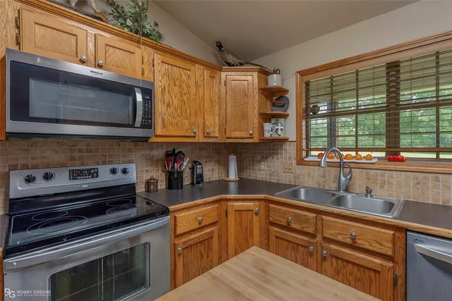 a kitchen with stainless steel appliances granite countertop a stove microwave and sink