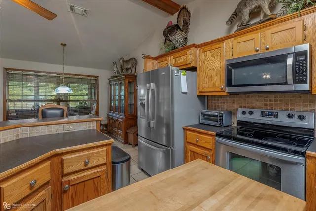 a kitchen with stainless steel appliances granite countertop a refrigerator and a stove top oven