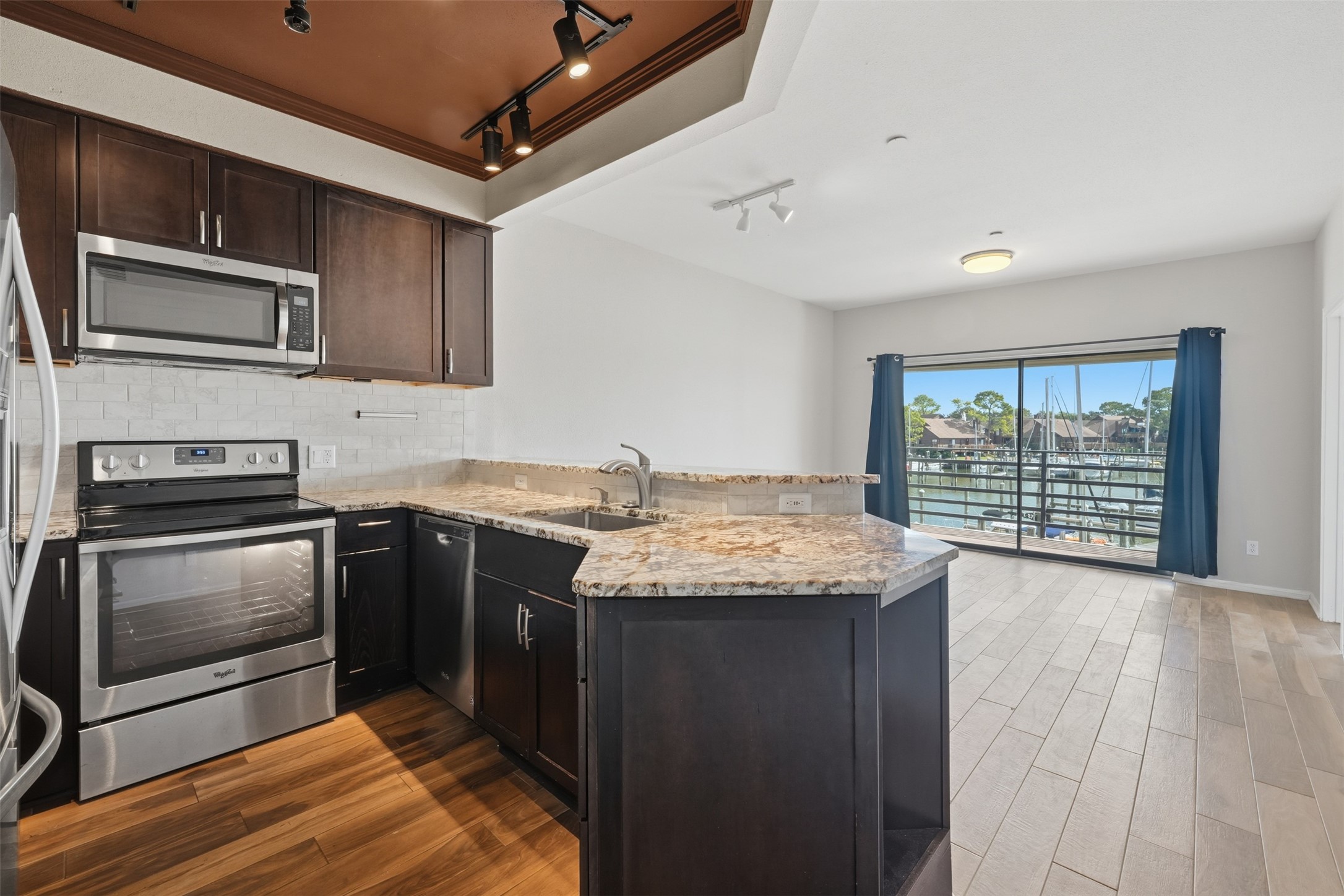 a kitchen with granite countertop stainless steel appliances and wooden cabinets