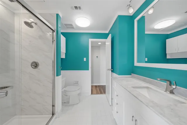 a bathroom with a sink a toilet and shower