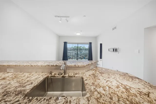 a view of a livingroom with wooden floor and kitchen space