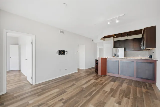 a kitchen with a sink and wooden floor