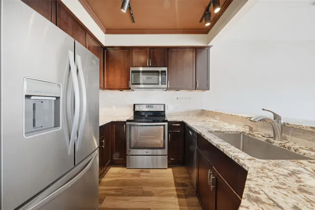 a kitchen with granite countertop a sink stove and microwave