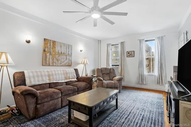 a living room with furniture a flat screen tv and a rug