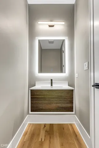 a hallway with wooden floor windows and a bathroom