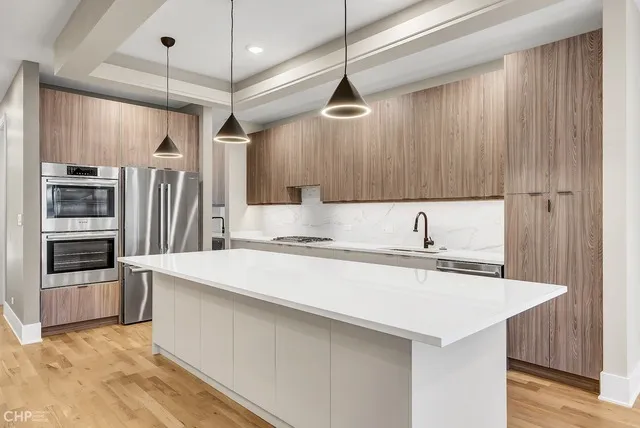 a large kitchen with kitchen island a sink stainless steel appliances and cabinets
