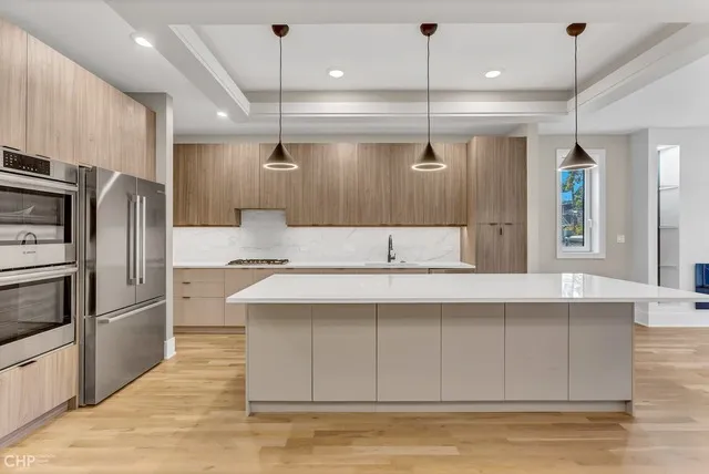 a kitchen with kitchen island a counter top space stainless steel appliances and cabinets
