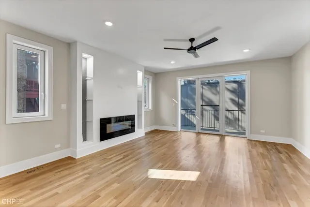 a view of a livingroom with wooden floor and a ceiling fan