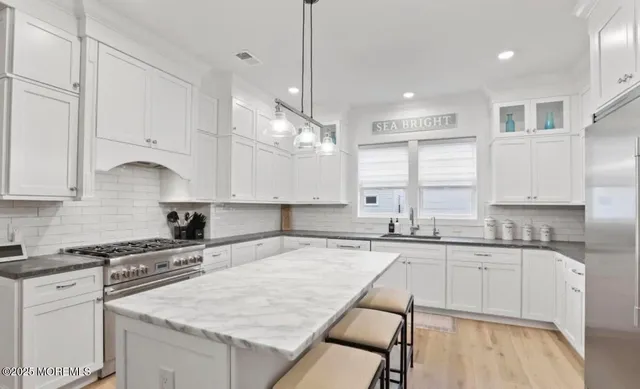 a kitchen with granite countertop a sink a counter top space appliances and cabinets