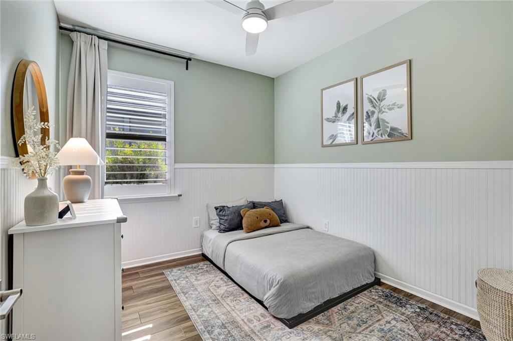 2240 Yellowfin Circle Naples, FL 34114 - Photo 15 of 38 Bedroom with an accent wall, plantation shutters, impact window, luxury plank flooring and a ceiling fan