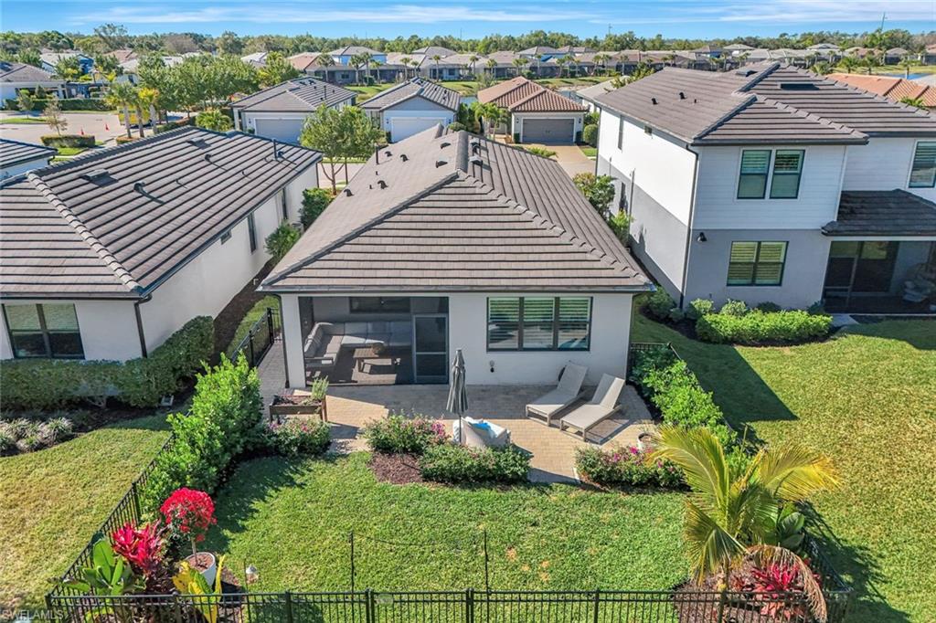 2240 Yellowfin Circle Naples, FL 34114 - Photo 2 of 38 Rear view of house featuring a tile roof, fenced in yard, an extended patio area, a sunroom, and a residential view