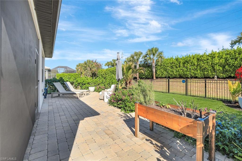 2240 Yellowfin Circle Naples, FL 34114 - Photo 20 of 38 Fenced backyard with an extended patio area with lush landscaping and outdoor lighting