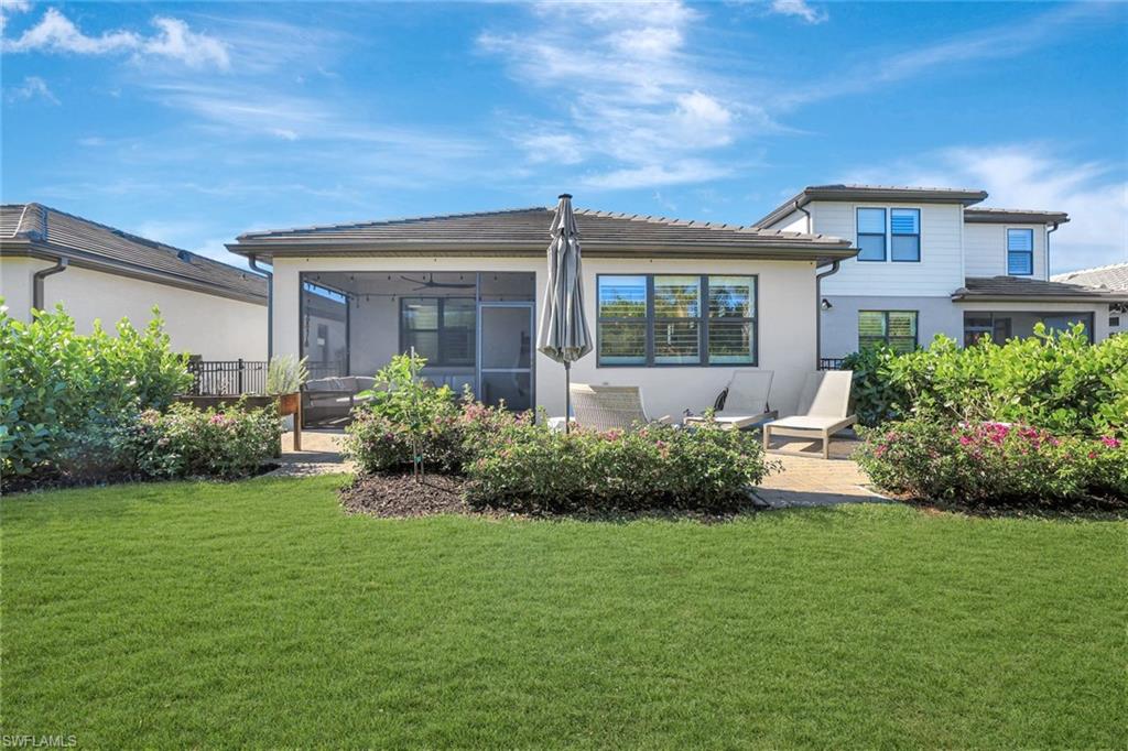 2240 Yellowfin Circle Naples, FL 34114 - Photo 22 of 38 Rear view of house with a fenced yard, tile roof and sunroom