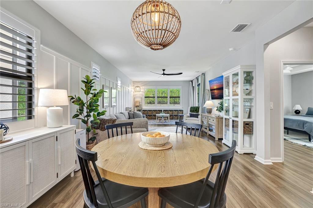 2240 Yellowfin Circle Naples, FL 34114 - Photo 6 of 38 Dining space featuring a chandelier, plantation shutters and view of accent wall
