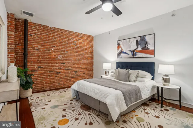 a bedroom with a bed and a wooden floor
